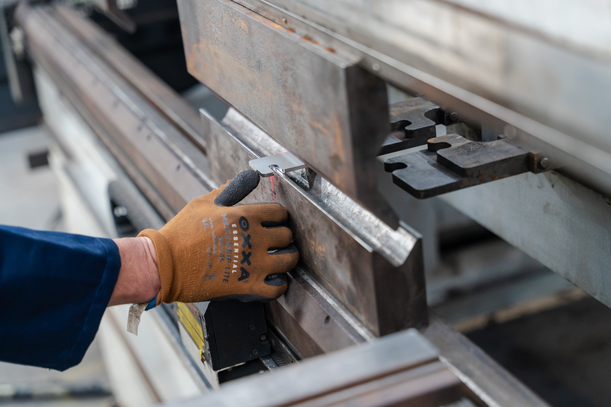 Een werknemer van Leenders nv werkt met een machine.